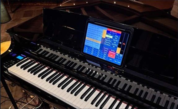 Quincy Arranger on a tablet above a digital piano.
